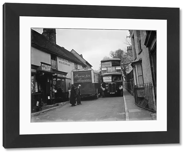 A butcher van and the number 21 bus squeeze past each other in the tight Farningham