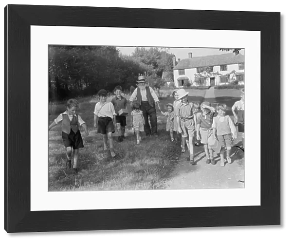 Evacuated children in Wye, Kent, walking down a country road. 1939  /  40