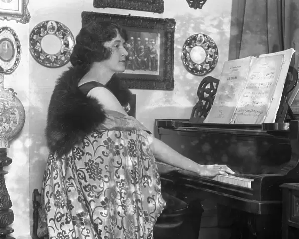 English actress, Miss Marjorie Hume seated at her piano