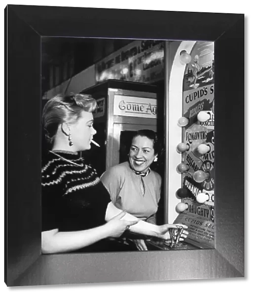Two women enjoying themselves playing the Arcade machine Cupids Secret