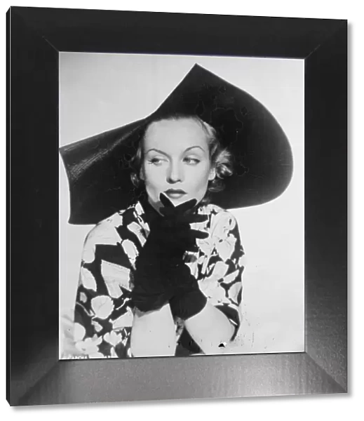 Scalloped Millinery. Carole Lombard, the Hollywood film actress, wearing a new