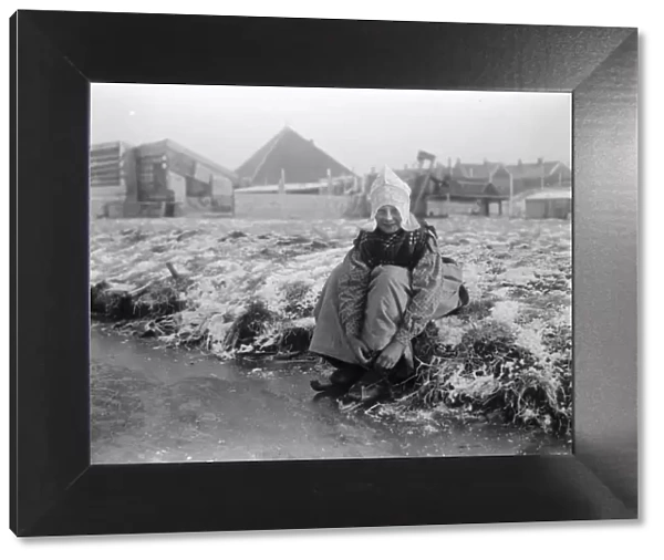 A Dutch Idyll A charming photograph of a jolly little Dutch girl preparing for