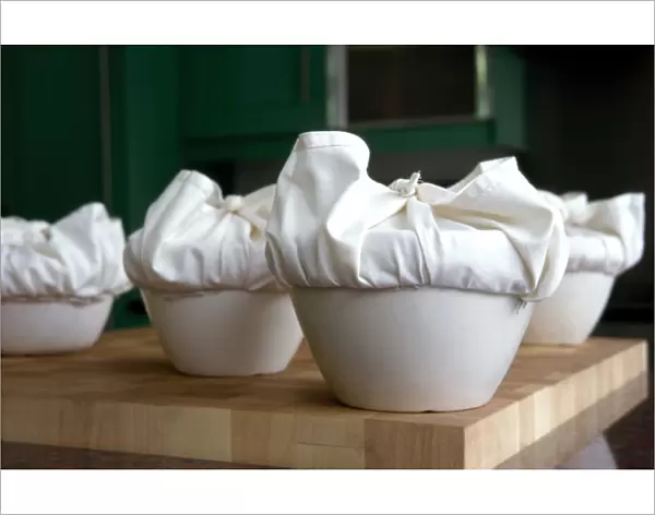 A batch of traditional English Christmas puddings, with cloths tied ready to steam