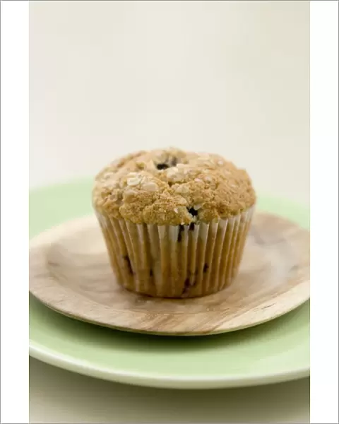 Healthy bran and raisin muffin on small wooden plate on green platter credit: Marie-Louise