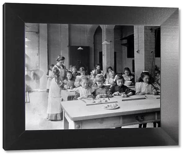 Edwardian school. Young girls, in the classroom, being supervised by their teacher