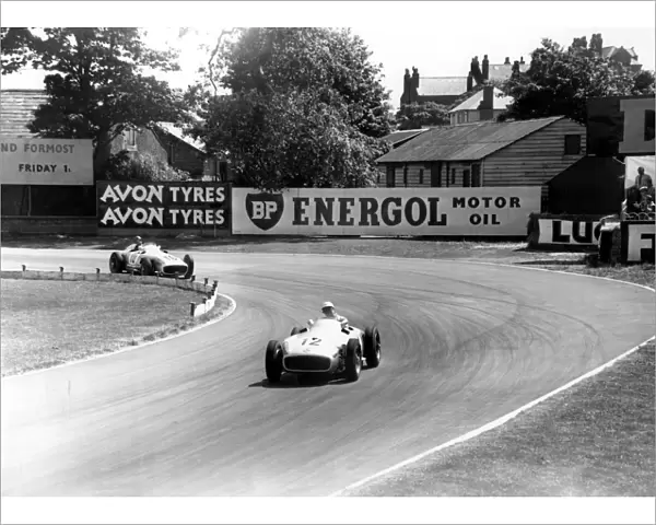 British racing driver Stirling Moss No 12, takes the lead from Fangio of Argentina