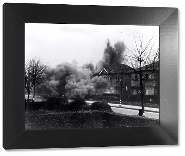 Smoke and debris thrown skywards after a direct hit from a German bomb in the suburbs