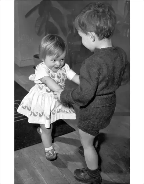 Boy and girl toddlers playing together dancing partners dance  /  dancing  /  party season