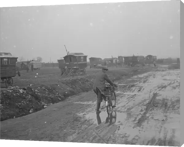 A cyclist negotiates a very muddy road with gypsy caravans parked on Belvedere marshes