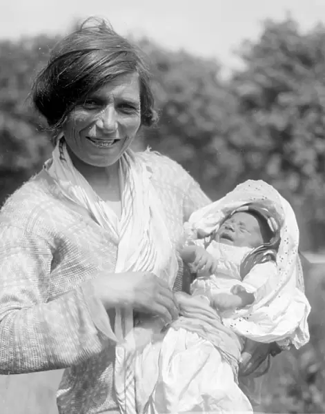 A Romany gypsy mother holds her baby at the Epsom Races. Late 1940s, early 1950s
