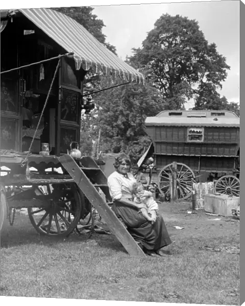 A Romany mother with her baby sitting on the steps of her caravan on Epsom Downs
