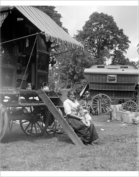 A Romany mother with her baby sitting on the steps of her caravan on Epsom Downs