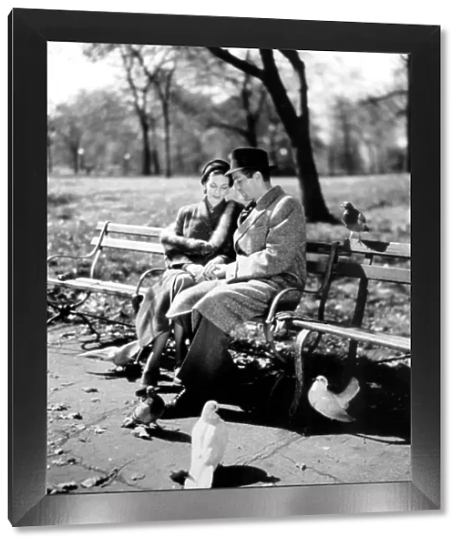 Romantic cliched couple. 1950 s. Couple having a quiet moment in the park