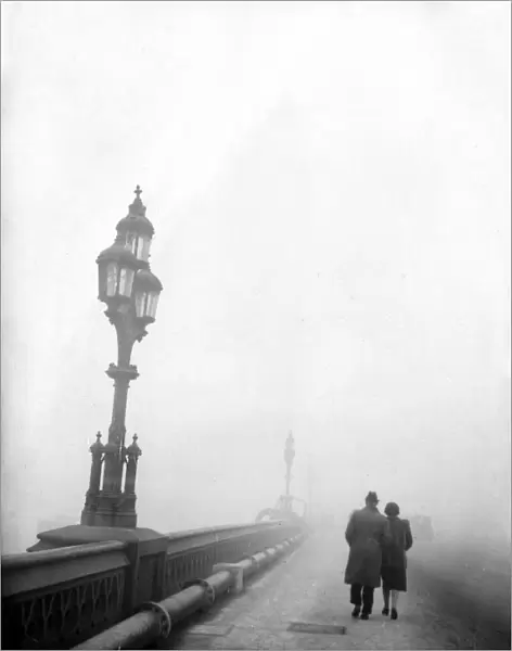 Couple walking across a bridge in London in fog 1950s love couple romance romantic