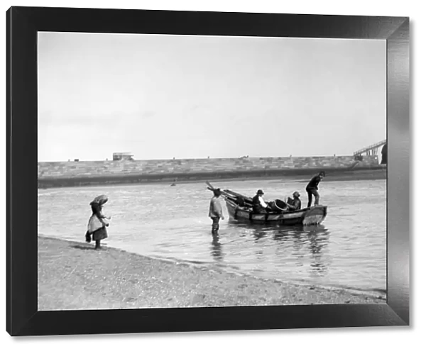 People out fishing from a Coble ( a locally made fishing boat ) at low tide, near