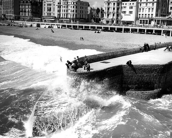 31 May 1958 Visitors to Brighton watch as seas break against the Groyne - ever