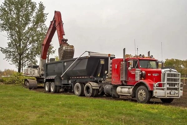 A 6x4 red Kenworth atic unit with a twin axle tipping trailer being loaded at Sudbury
