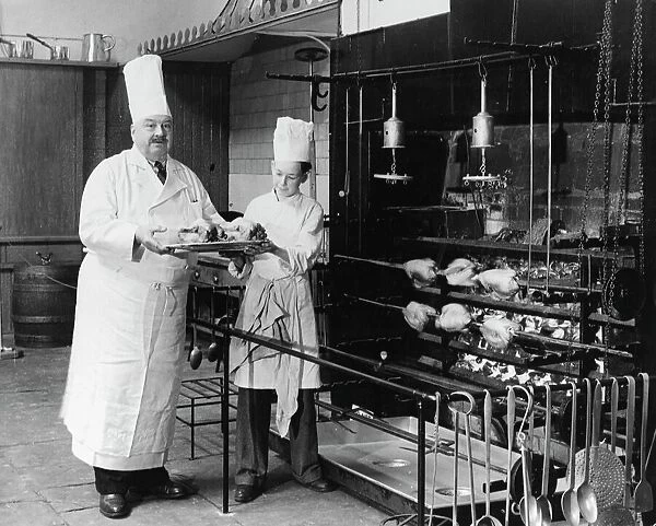 A. H. Cadier, senior chef at the Brighton Pavilion is handed fake chickens by junior
