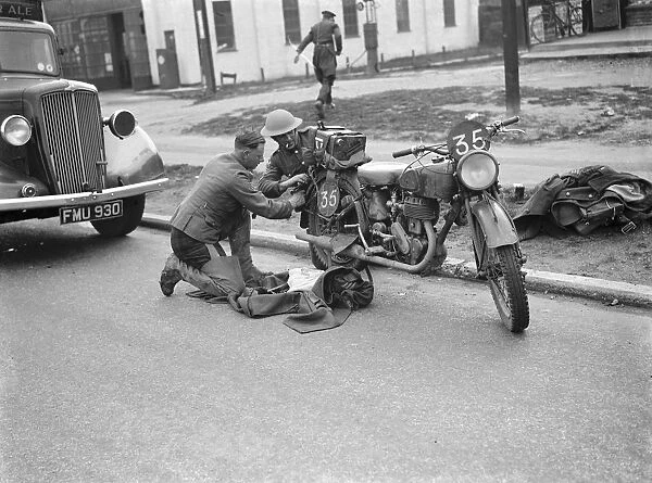 An army motorcyclist performs some maintenance on his Royal Enfield 25 CC motorcycles
