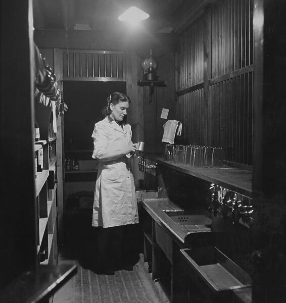 A barmaid cleaning a beer tankard in the Globe Tavern. A state owned pub in Longtown
