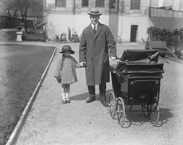 Barrister M P wheels a perambulator Col J P Hodge, M P takes his little son out