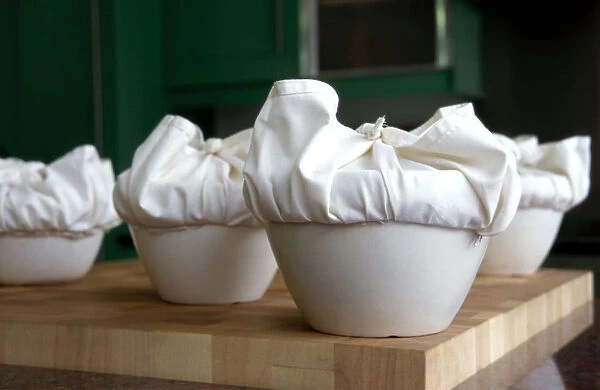 A batch of traditional English Christmas puddings, with cloths tied ready to steam