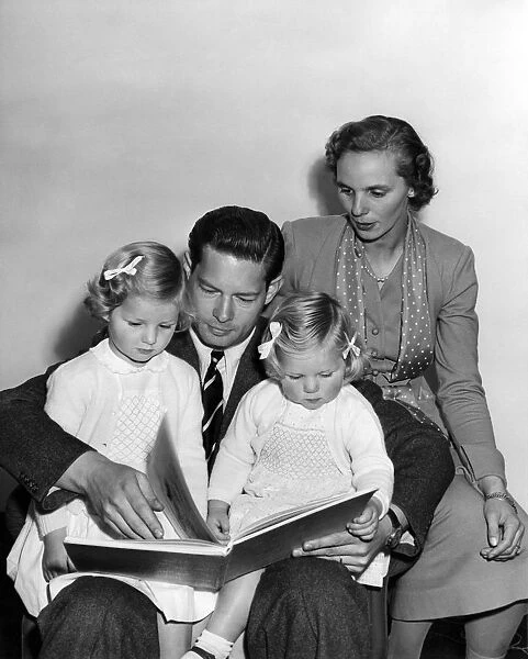A bedtime story for Princess Margaret (3 1  /  2) and Princess Helen (2) is read by father