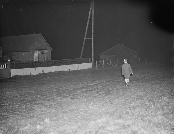 A boy, walking down Church Road in Kingsdown, Kent. 12 December 1938