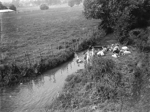 Boys paddling in stream. 1935