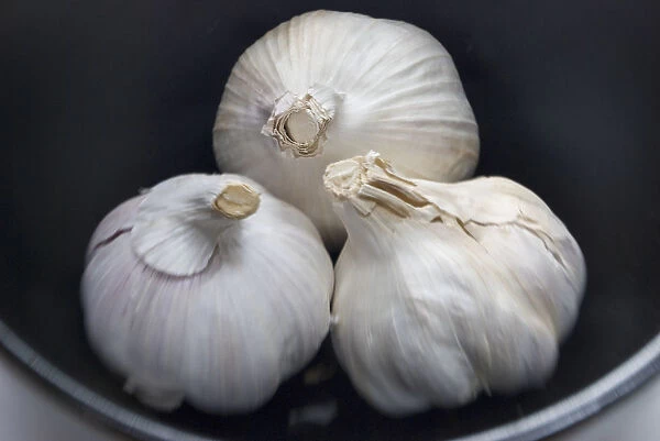 Three whole bulbs of garlic in black bowl credit: Marie-Louise Avery  /  thePictureKitchen