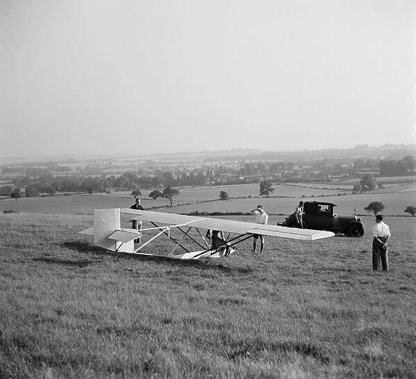 A Cessna CG-2 Glider is being hitched up to its tow line, in preperation for its