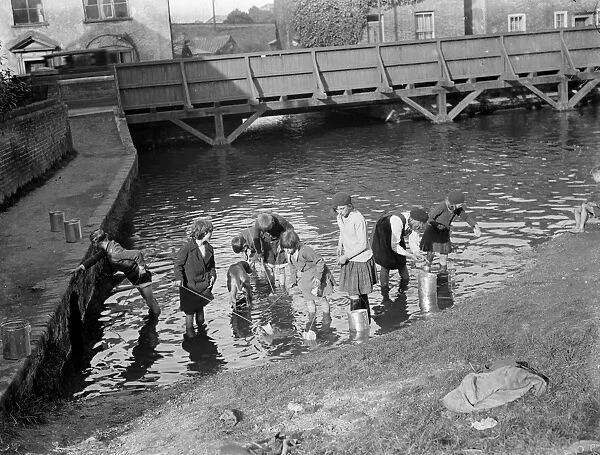 Children enjoying paddling and fishing for tiddlers at Bexley in Kent