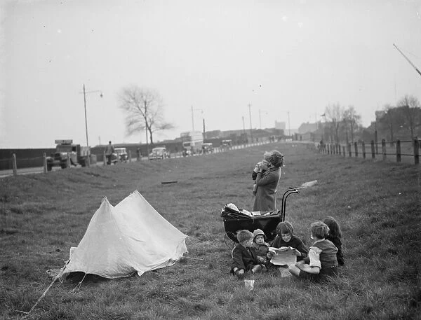 Children have a picnic on a bit of grass next to the road. 1938
