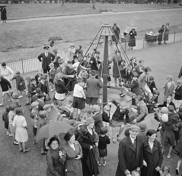 Children playing on the top hat roundabout at the childrens playground in Crayford