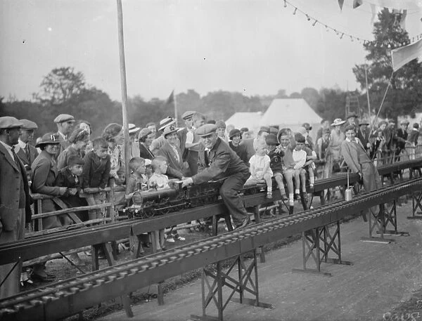 Children ride on a miniature railway. 1938