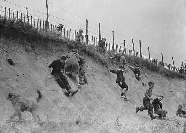 Children sliding down the bank. 1937