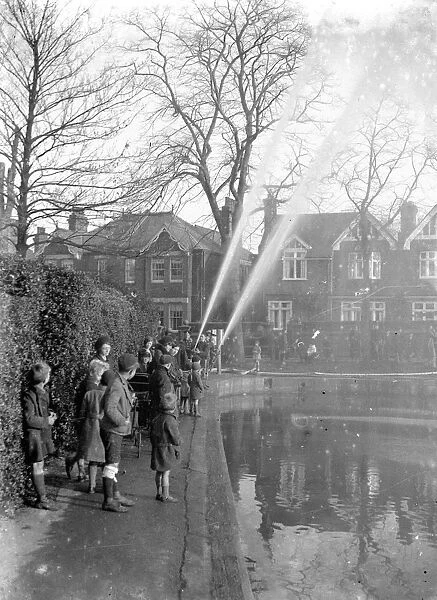Children watching firemen dealing with flames in Chislehurst, Kent. 1933