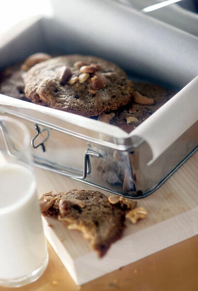Chocolate nut cookies in paper lined storage tin credit: Marie-Louise Avery  /  thePictureKitchen