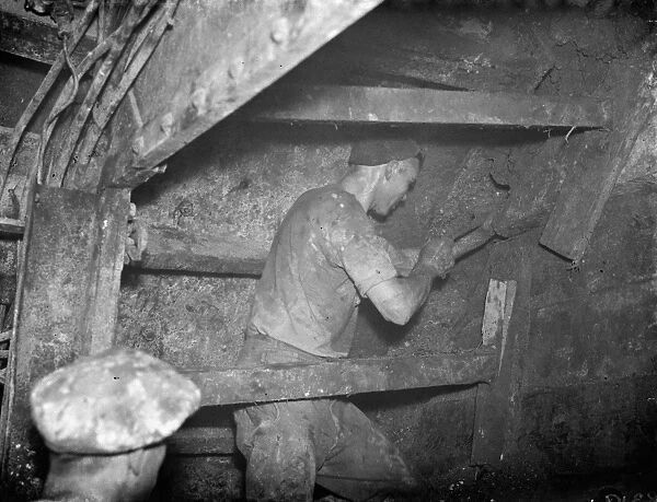 The construction of the Dartford Tunnel. A workmen digging by the shield