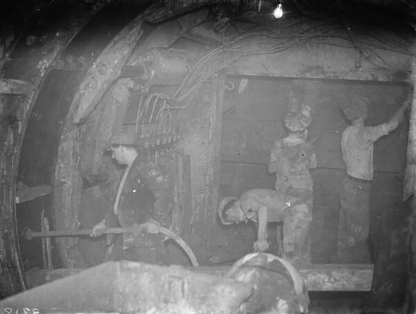 The construction of the Dartford Tunnel. Workmen by the shield and injecting cement