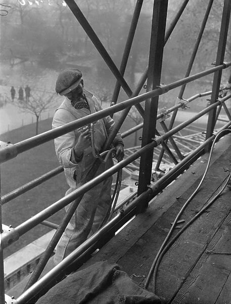 Coronation spray by masked workmen. A workman wearing a special mask as he sprays