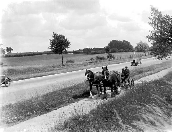 Country roads were almosts empty of traffic.Here in 1936 a car passes a horsedrawn mower