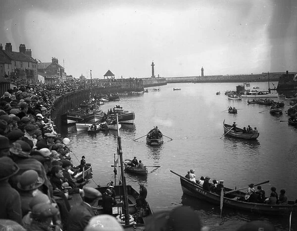 Crowds at Whitby harbour watching the rowing boats on the River Esk, Yorkshire