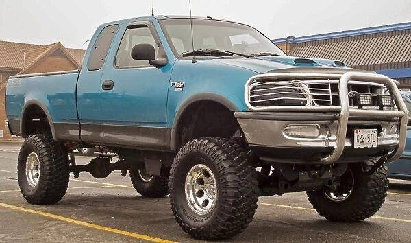 A customized Ford F150 with big wheels and tyres outside a Dairy Queen fast food