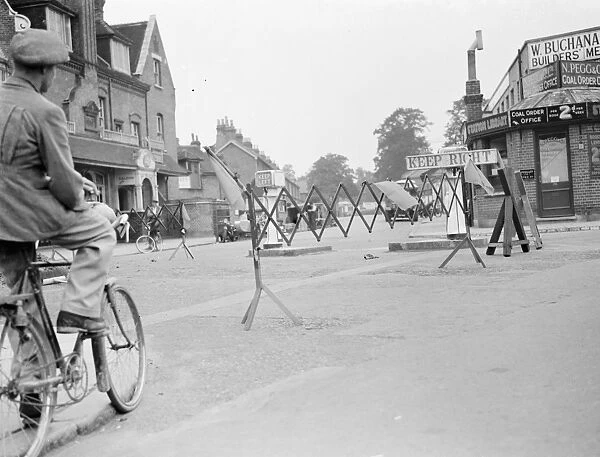A cyclist negotiates a road barricade for road works in Bromley, Kent
