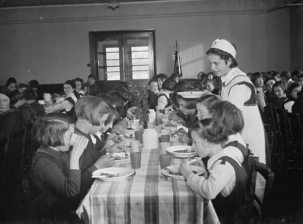 The dinner lady serving lunch at a girls school in Orpington, Kent. 1937