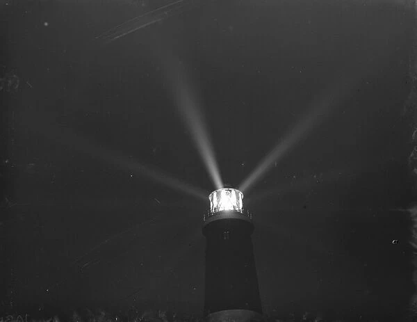 Dungeness lighthouse send out its light by night over Dungeness Point, Kent, which