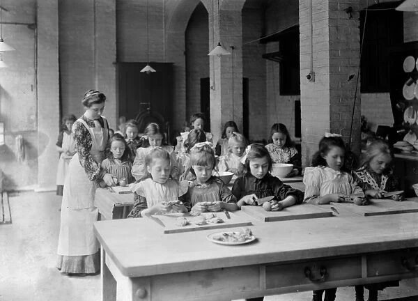 Edwardian school. Young girls, in the classroom, being supervised by their teacher