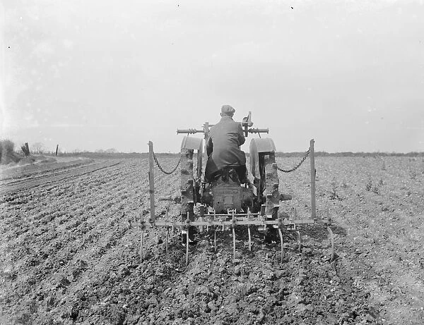 A farmer on his tractor cultivate a field. 1935