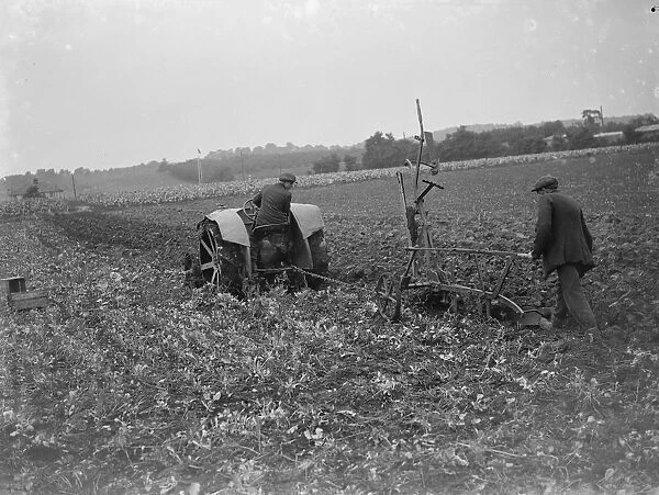 A farmer and his tractor plough a field. 1935